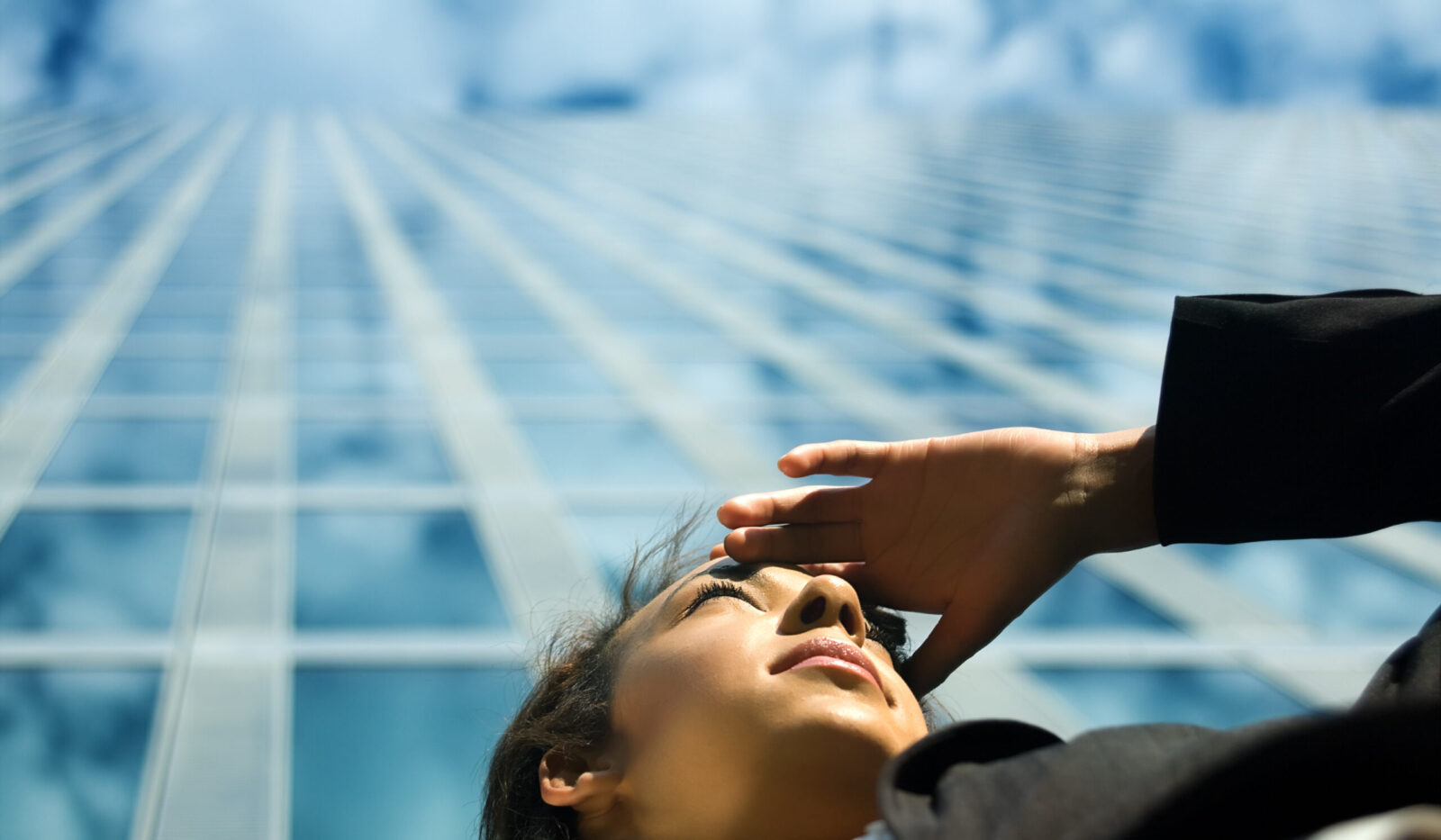 A New Investment Landscape - 2023 Market Outlook - Woman looking into distance below skyscraper