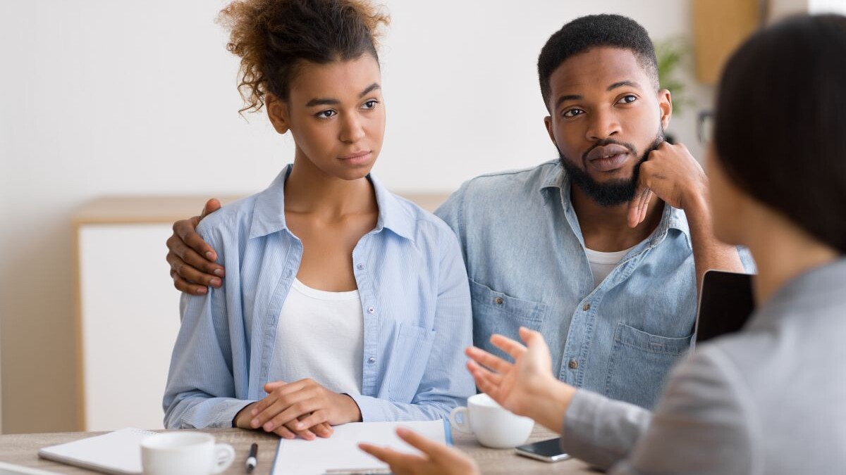 Young couple listening to femail financial retirement advisor