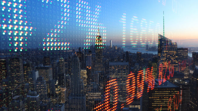 Stock ticker data overlaid on top of a photo of the Manhattan skyline at sunrise