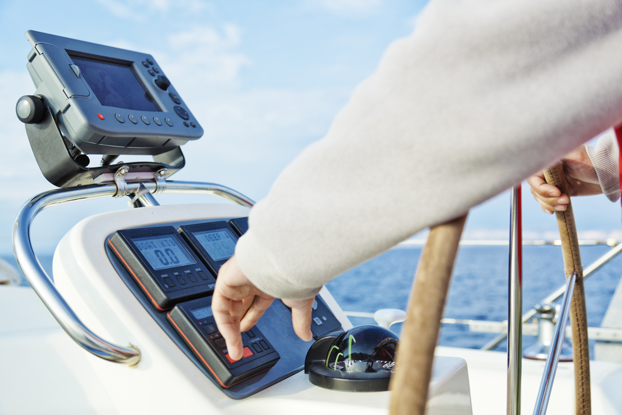skipper adjusting navigating yacht's auto pilot
