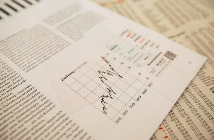 Reports and documents on top of a newspaper.