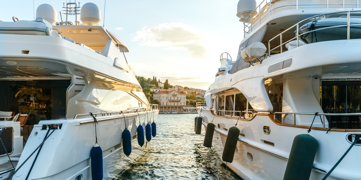 Large luxury yachts moored in the port of a tourist Mediterranean city in sunset light