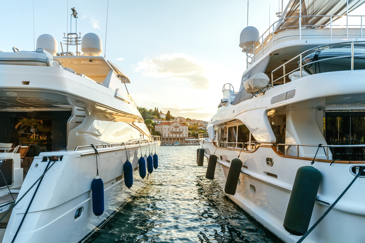 Large luxury yachts moored in the port of a tourist Mediterranean city in sunset light