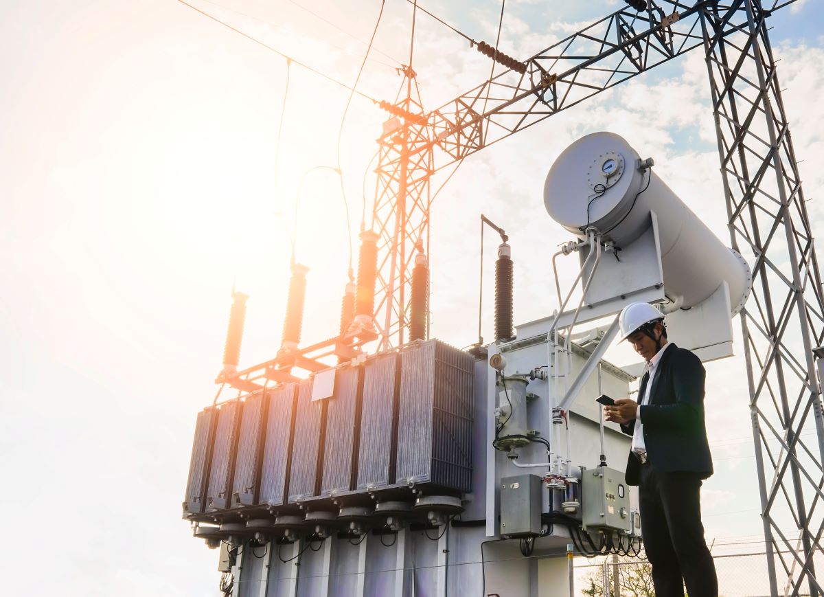 man under oil rig, investor looking at phone, energy transition