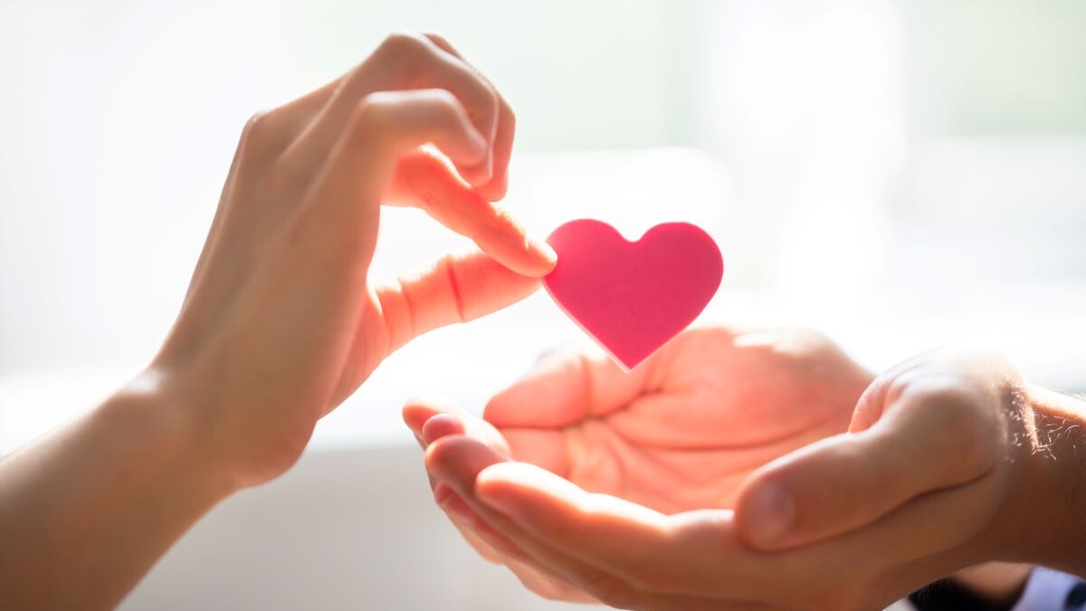 Woman Giving Heart On Man's Hand