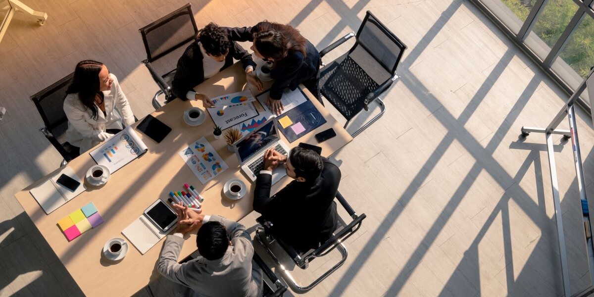 igh angle view of business woman advise patner with empathy during meeting session in office, diversity business people, financial discuassion, good relationship in work place