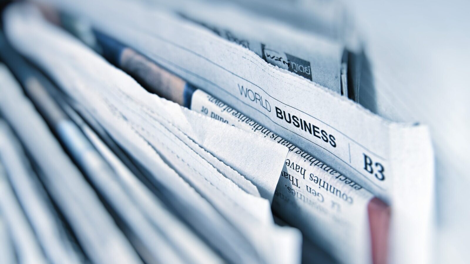 newspaper pile with business page showing