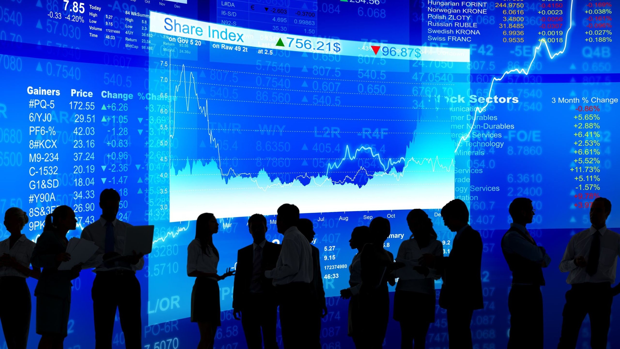 People in silhouette in front of market reports on a large screen.