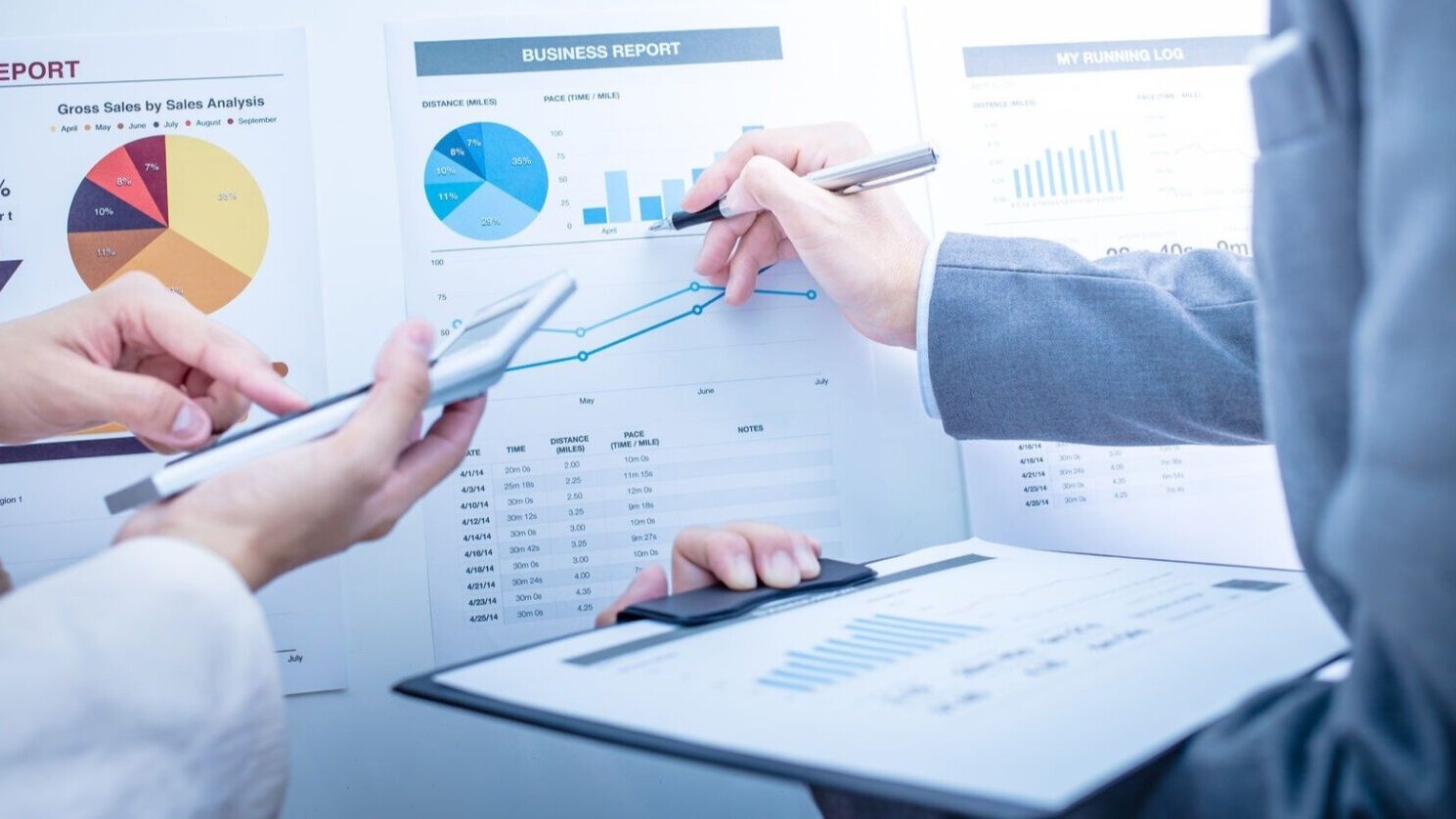 Business person holding a clipboard, reviewing business reports.