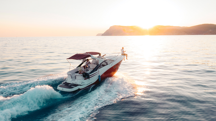 A speed boat driving into a sunset.