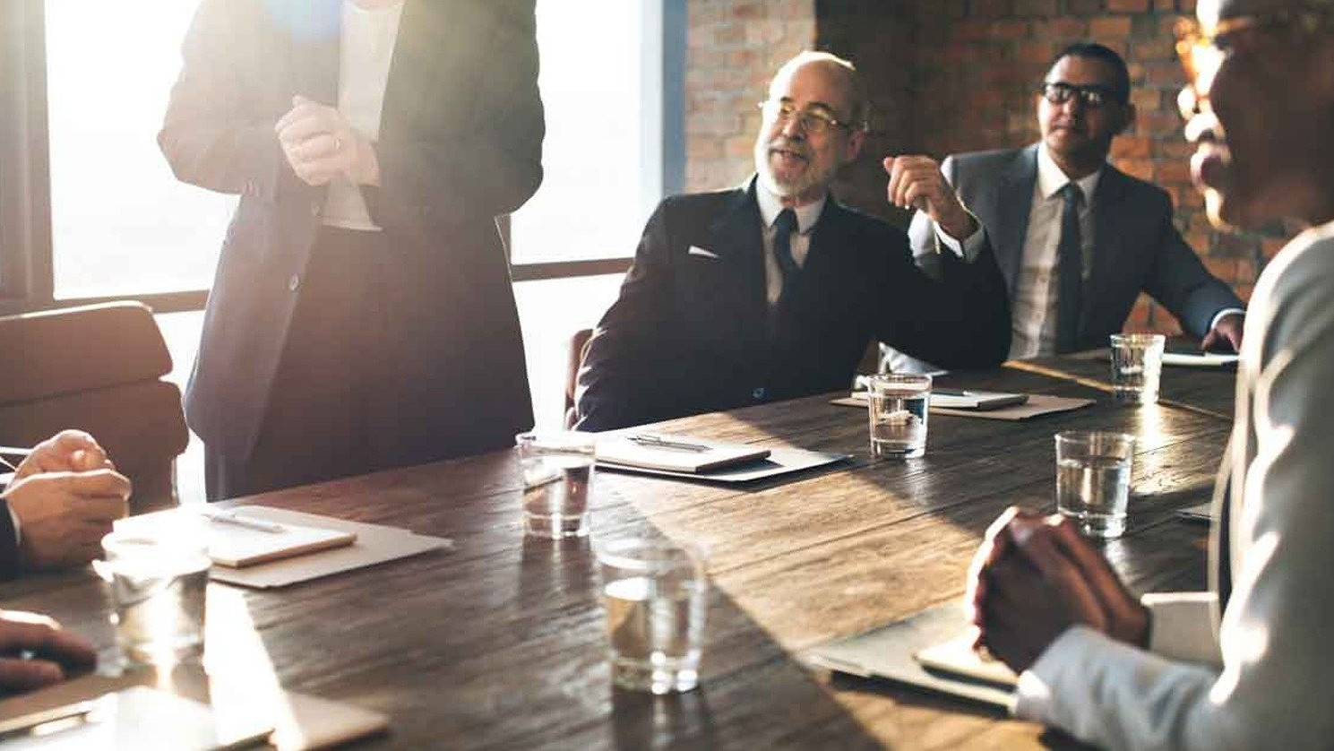 A warmly lit conference room with attendees around the table.