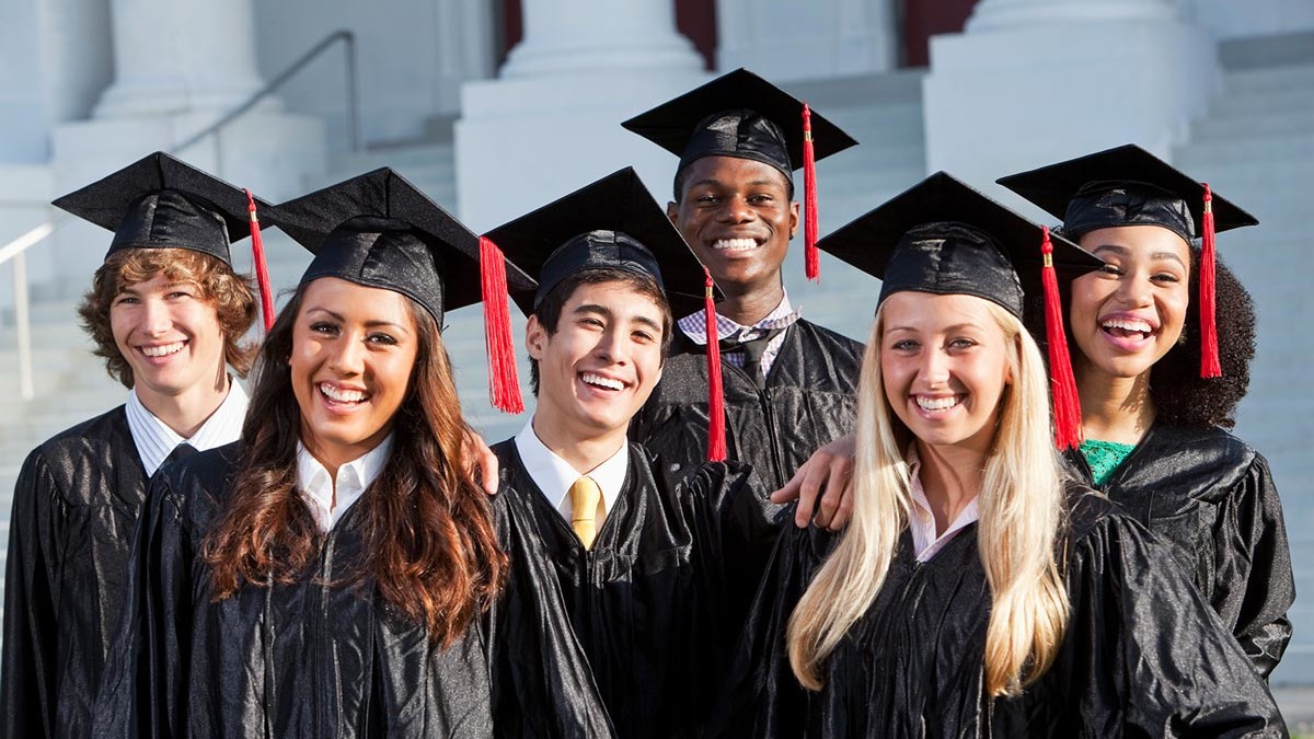 A group of 6 college graduates in cap and gown attire.