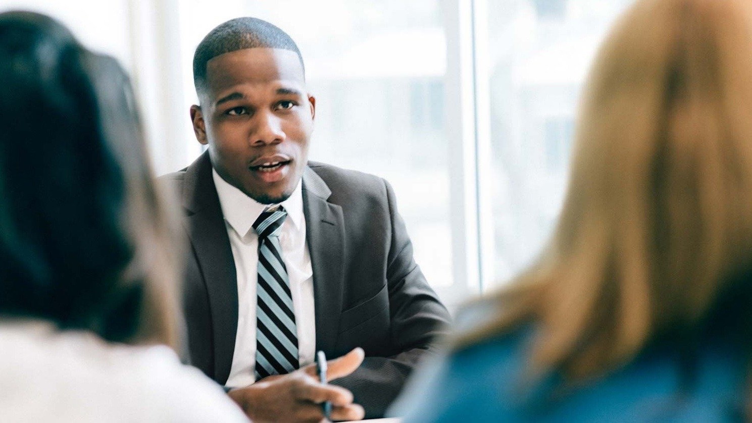 Businessman Talking to colleagues across a table.