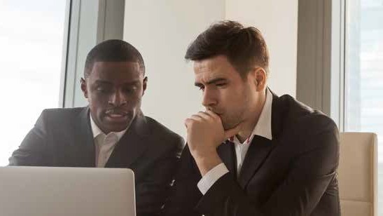 Two business people reviewing a laptop.