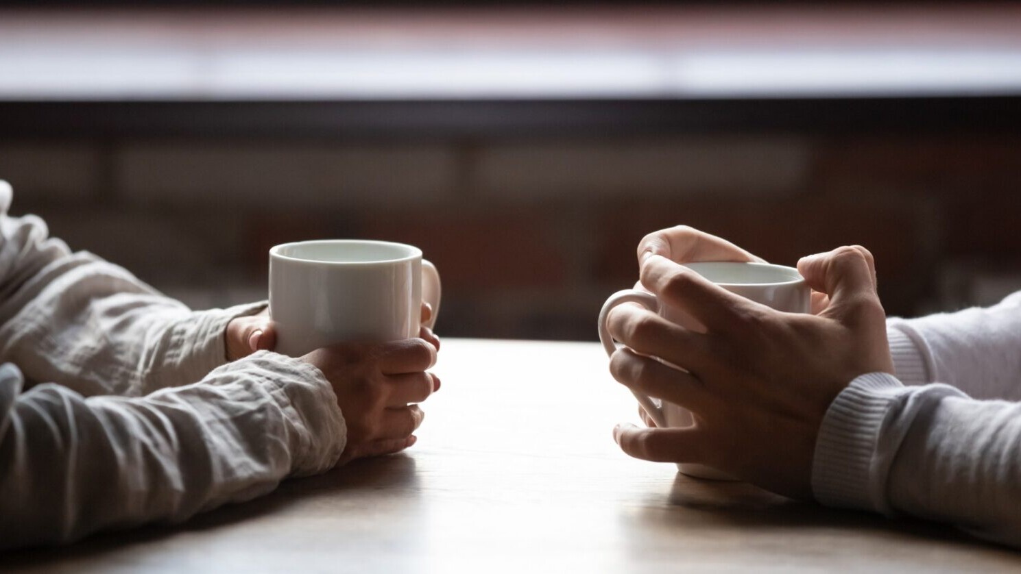 Facing colleagues with porcelain coffee cups.