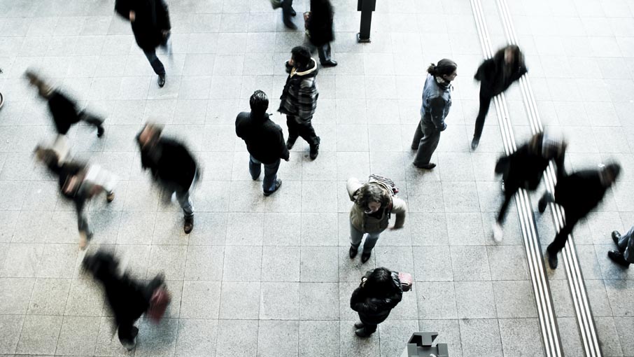 Birds eye view of commuters moving through a public space.