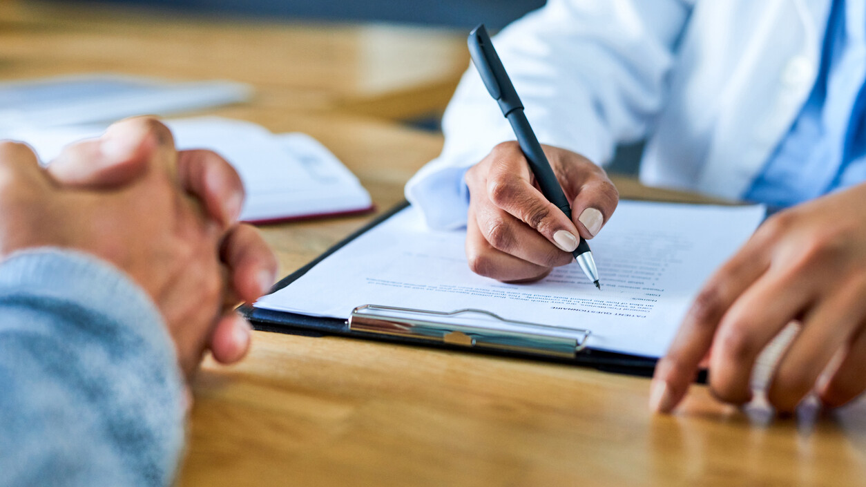 Closeup shot of a doctor writing notes during a consultation with a patient