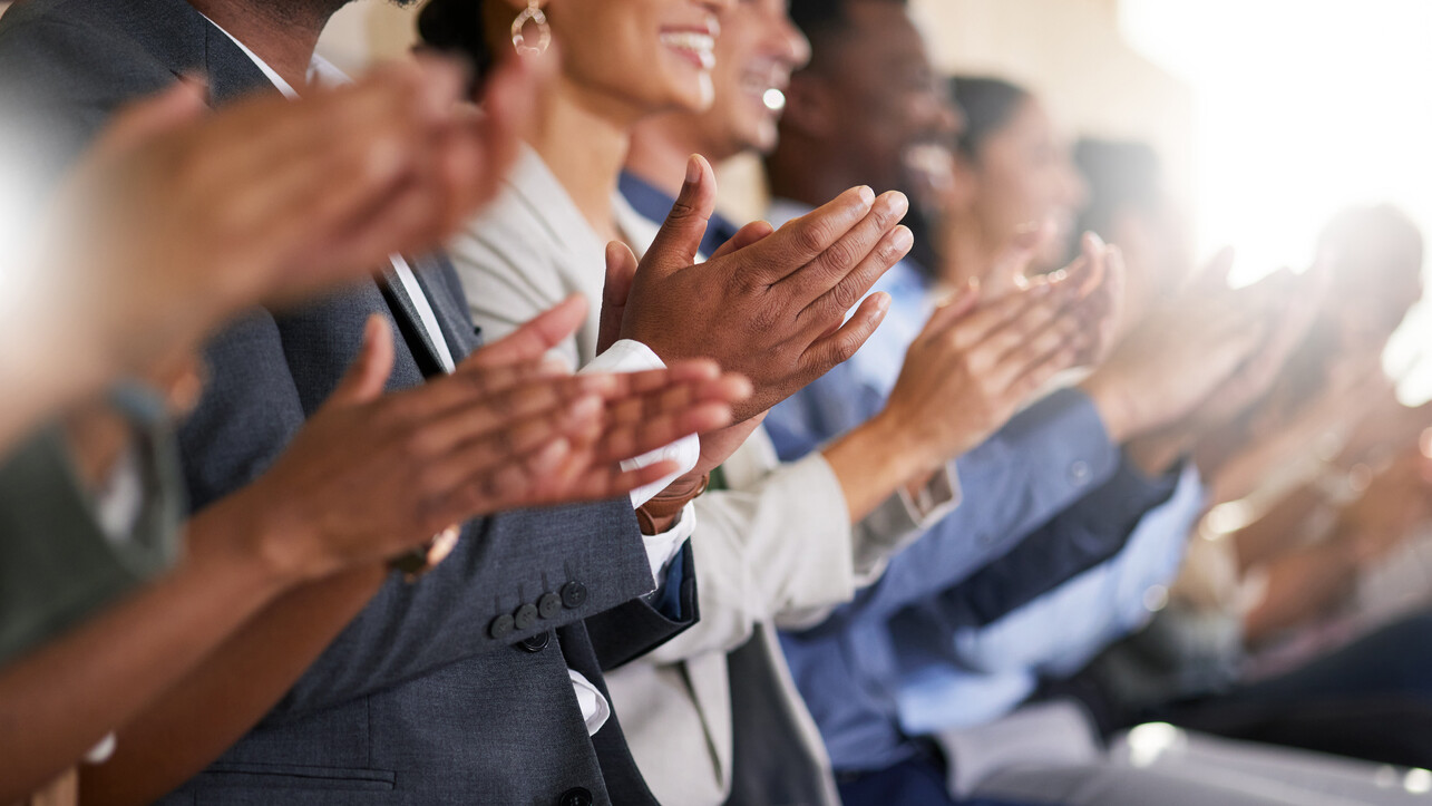 Cropped shot of an unrecognizable diverse group of businesspeople applauding while sitting in the boardroom during a presentation