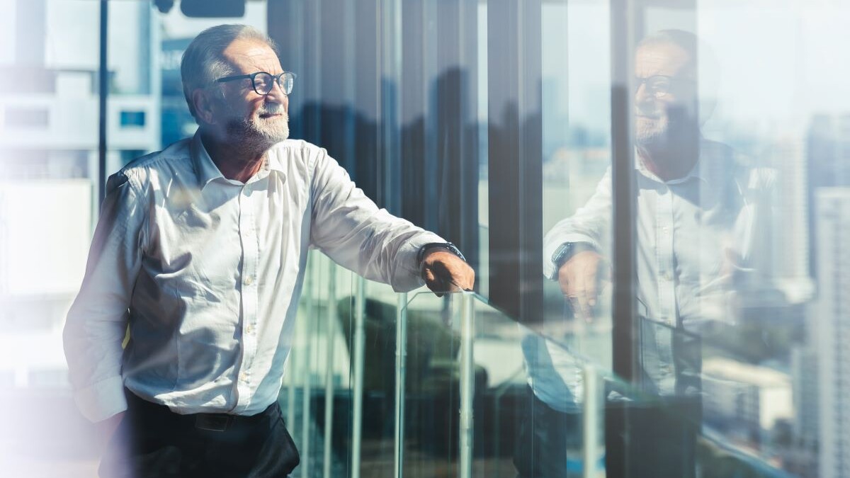 Retirement aged business man looking out office window