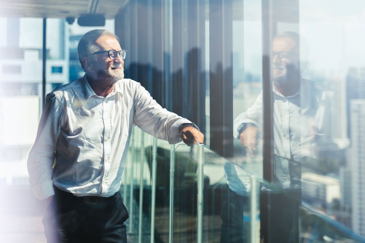 Retirement aged business man looking out office window