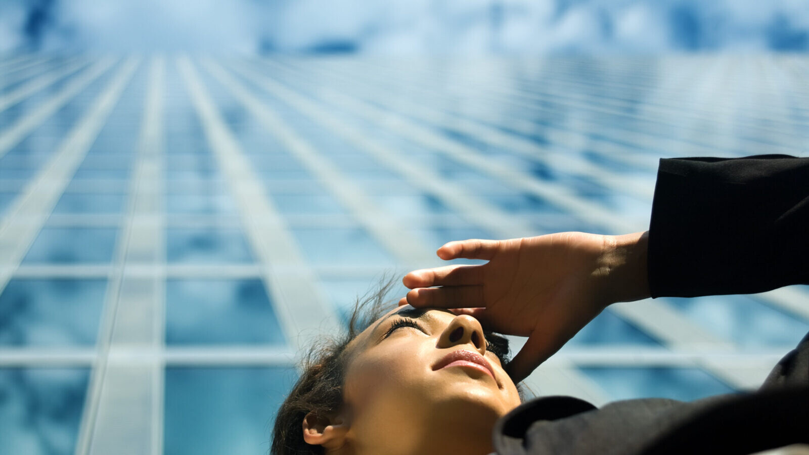 A New Investment Landscape - 2023 Market Outlook - Woman looking into distance below skyscraper