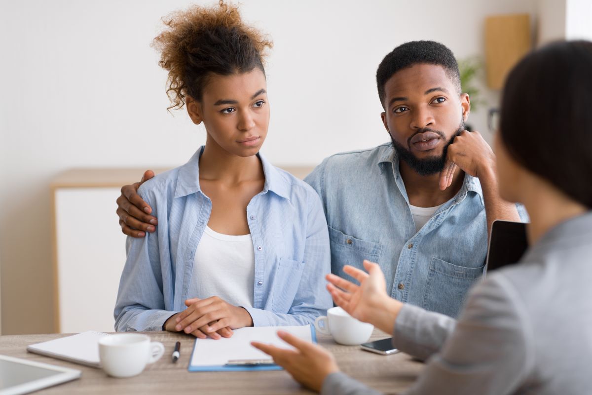 Young couple listening to femail financial retirement advisor