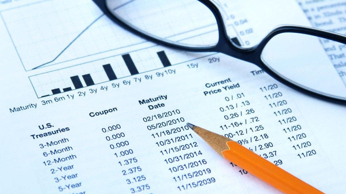 Glasses and pencil on top of paper about treasury and yield bonds