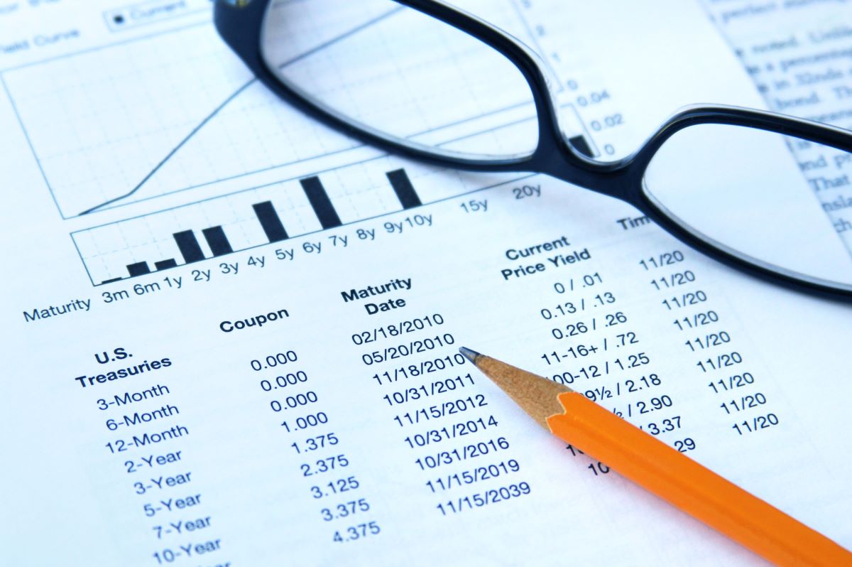 Glasses and pencil on top of paper about treasury and yield bonds