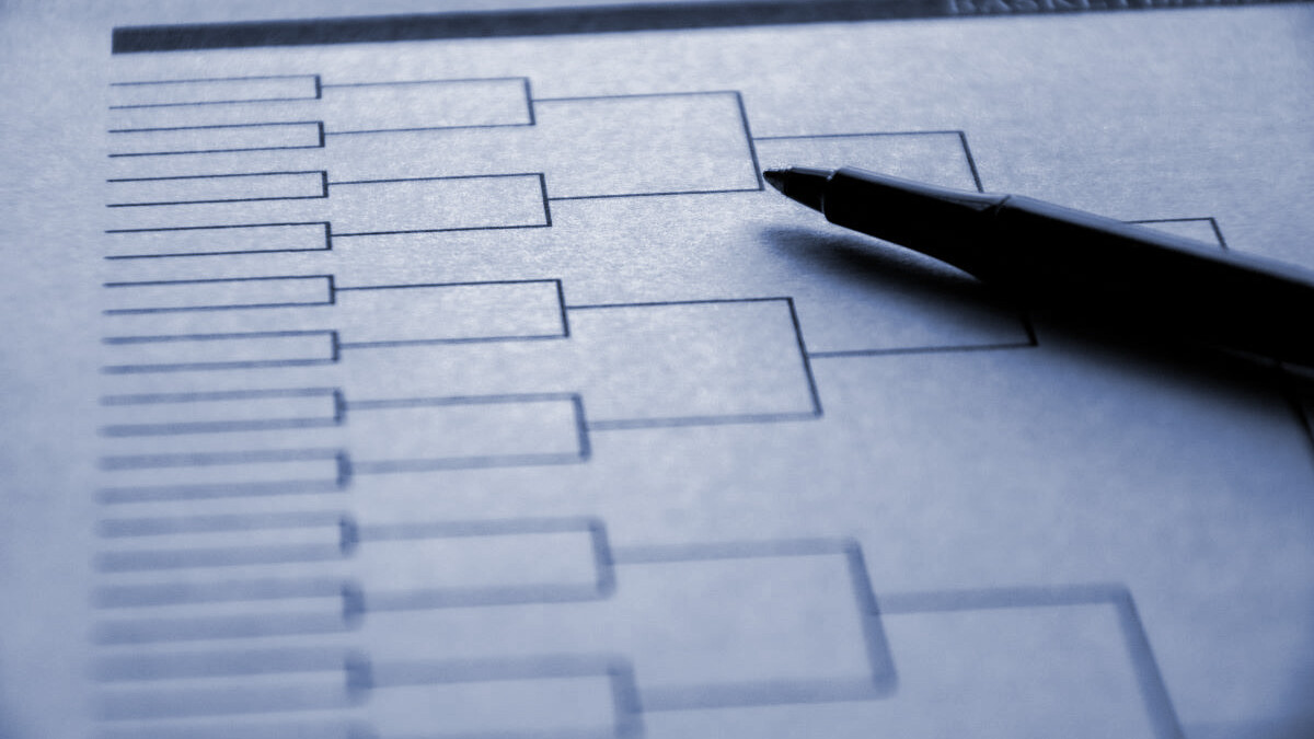 Blank basketball bracket grid on white paper with pen laying on top