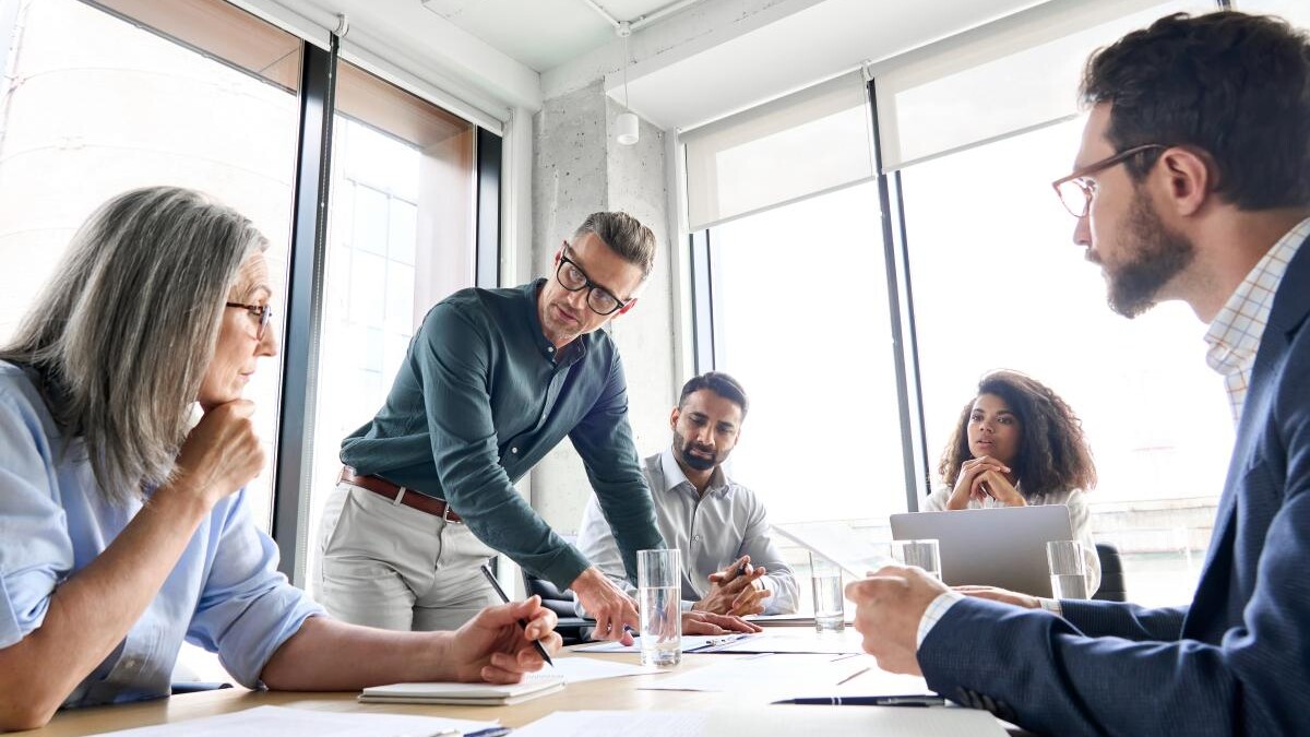 Advisors meeting, both male and female, in office setting around conference table