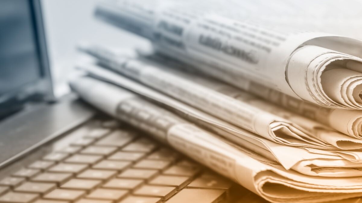 The concept of news. Folded stack of Newspapers on laptop