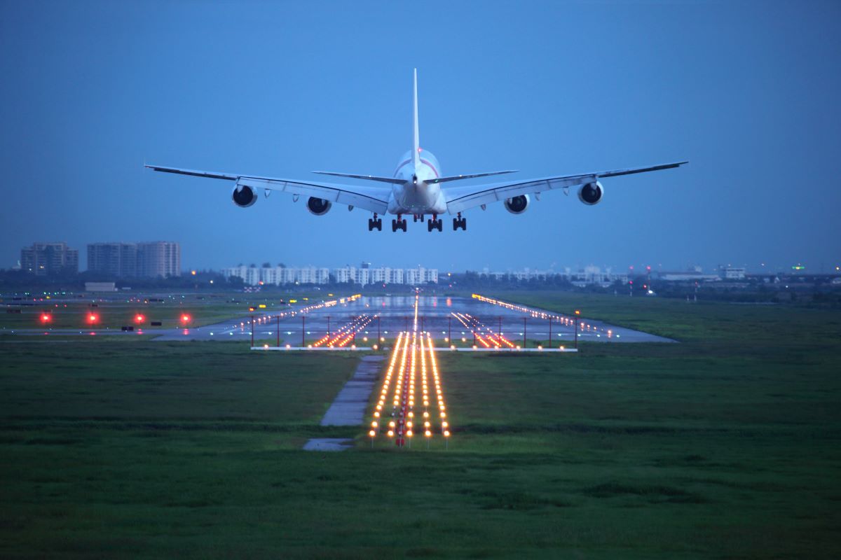 passenger plane flying up over take-off runway from airport