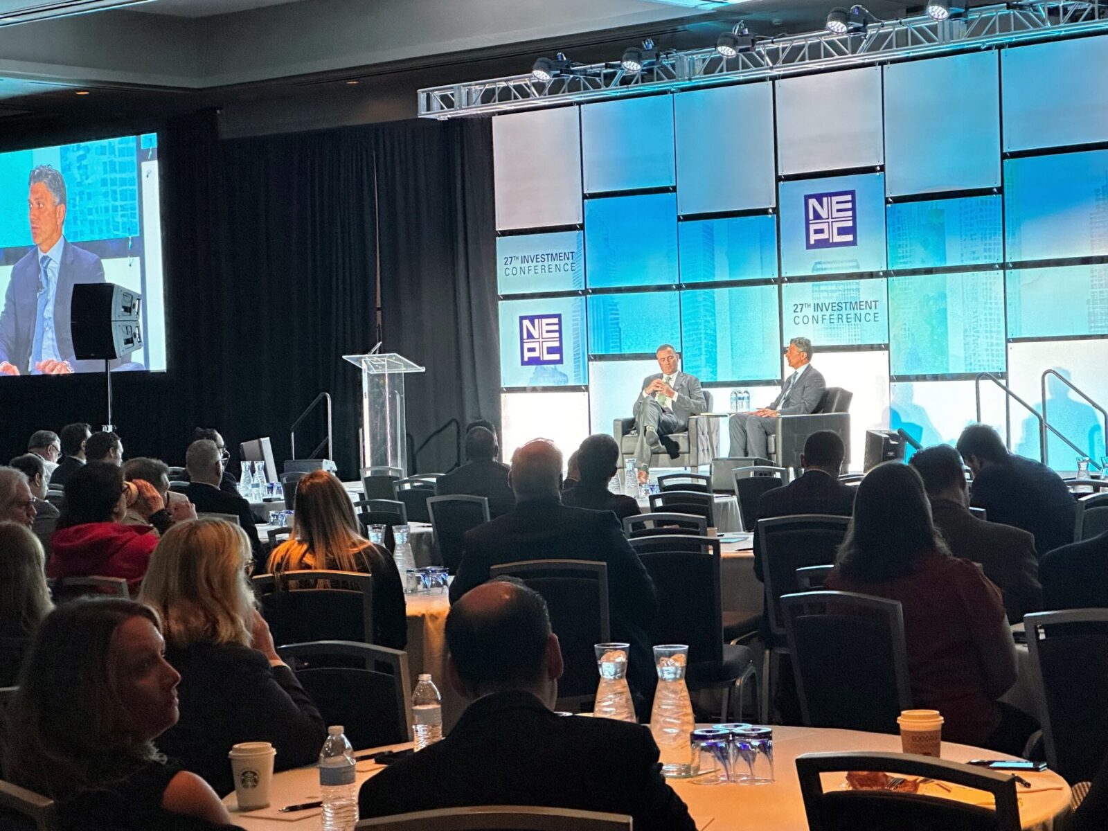 Tim McCusker and guest speaker on stage at NEPCs 27th annual investment conference