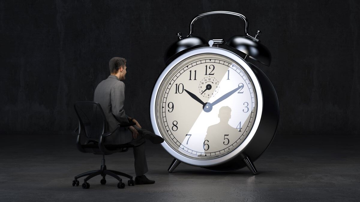 businessman waiting in front of clock