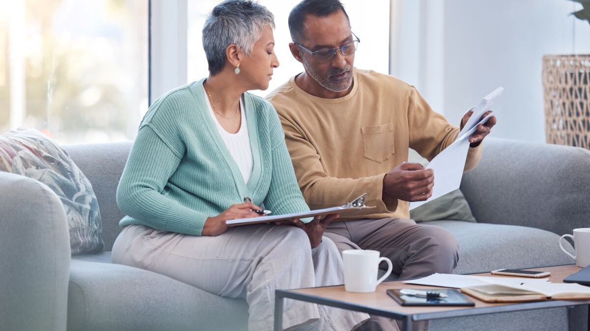 Finance, documents and senior couple on sofa with bills, paperwork