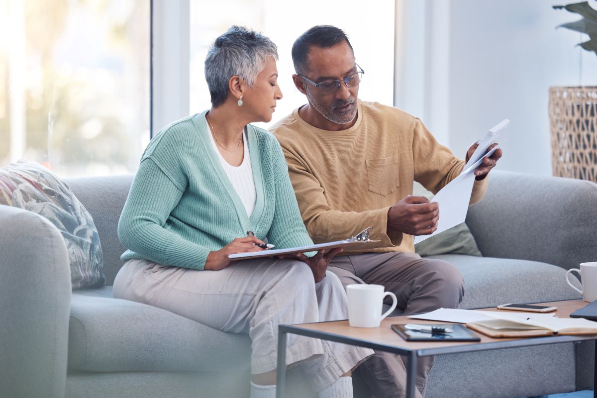 Finance, documents and senior couple on sofa with bills, paperwork