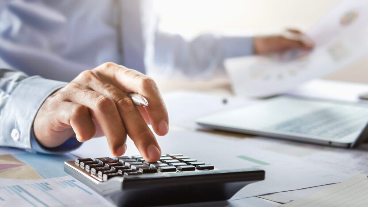 businessman typing on calculator