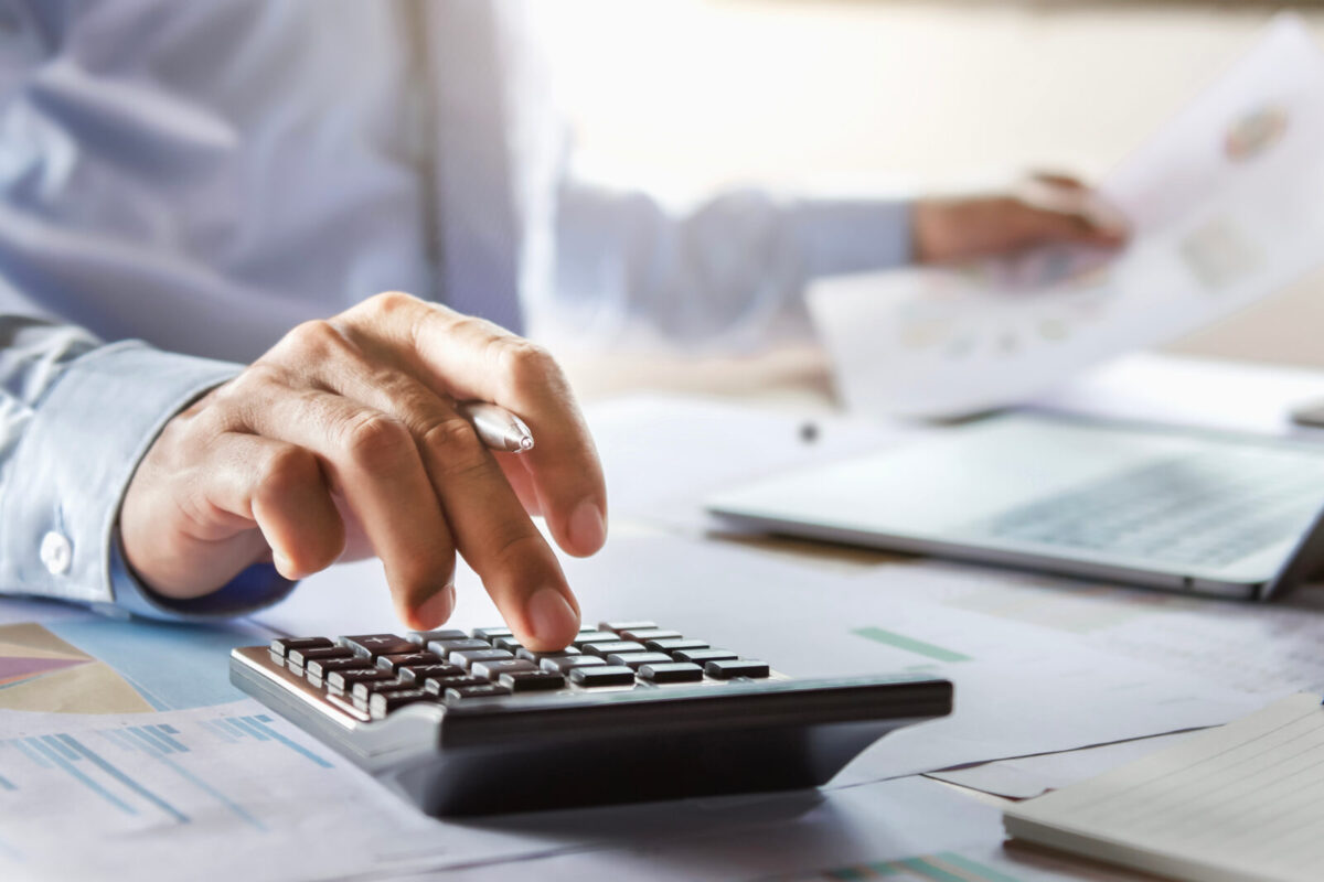 businessman typing on calculator