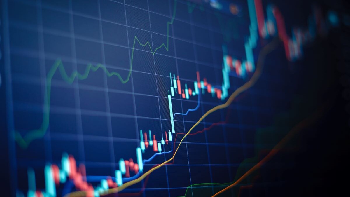 Closeup financial chart with uptrend line candlestick graph in stock market on blue color monitor background
