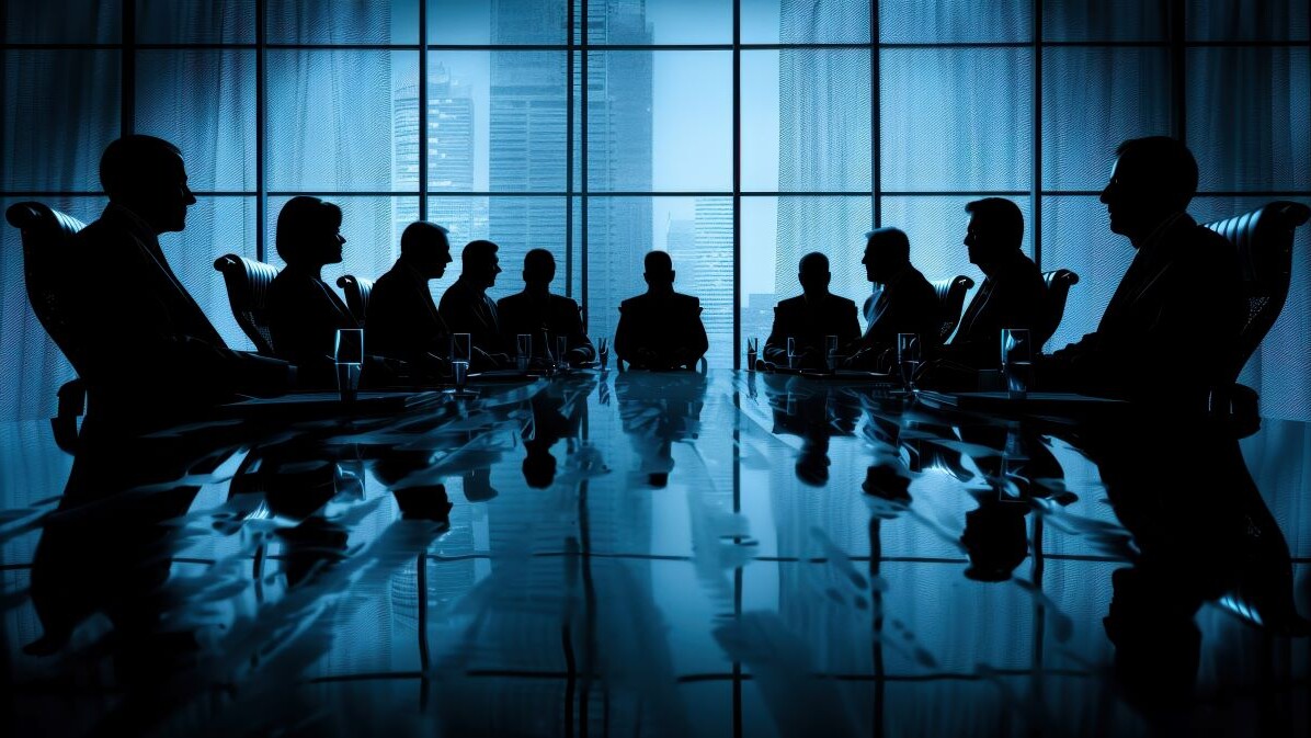 image of employees sitting around conference room table