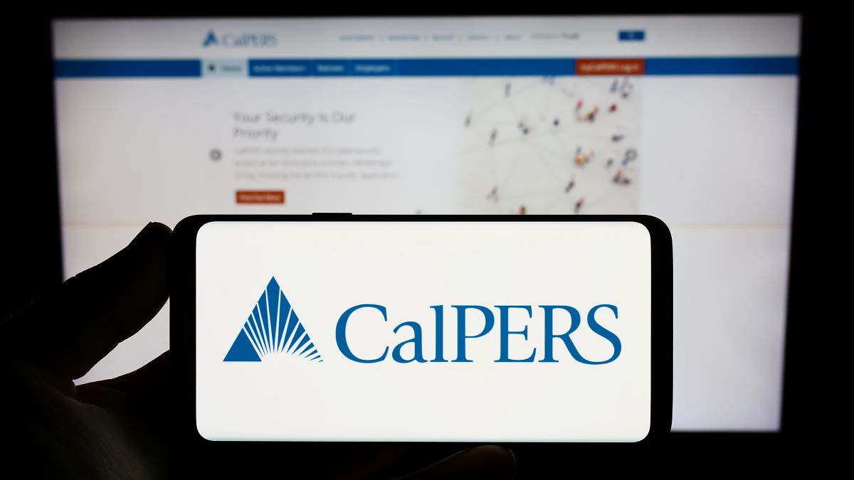 Stuttgart, Germany - 07-12-2023: Person holding smartphone with logo of Californian retirement system CalPERS on screen in front of website. Focus on phone display.