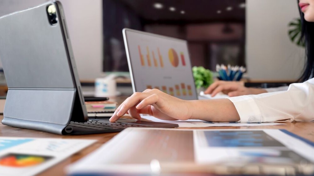 Businesswoman working at office with document on her desk, doing planning analyzing the financial report, business plan investment, finance analysis concept. Using laptop and tablet.