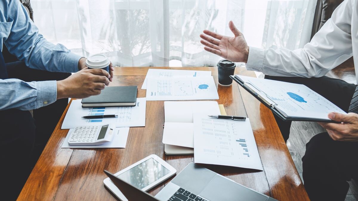 two businessmen meeting about financials over coffee