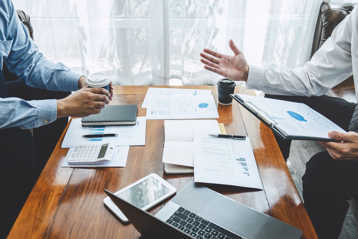 two businessmen meeting about financials over coffee