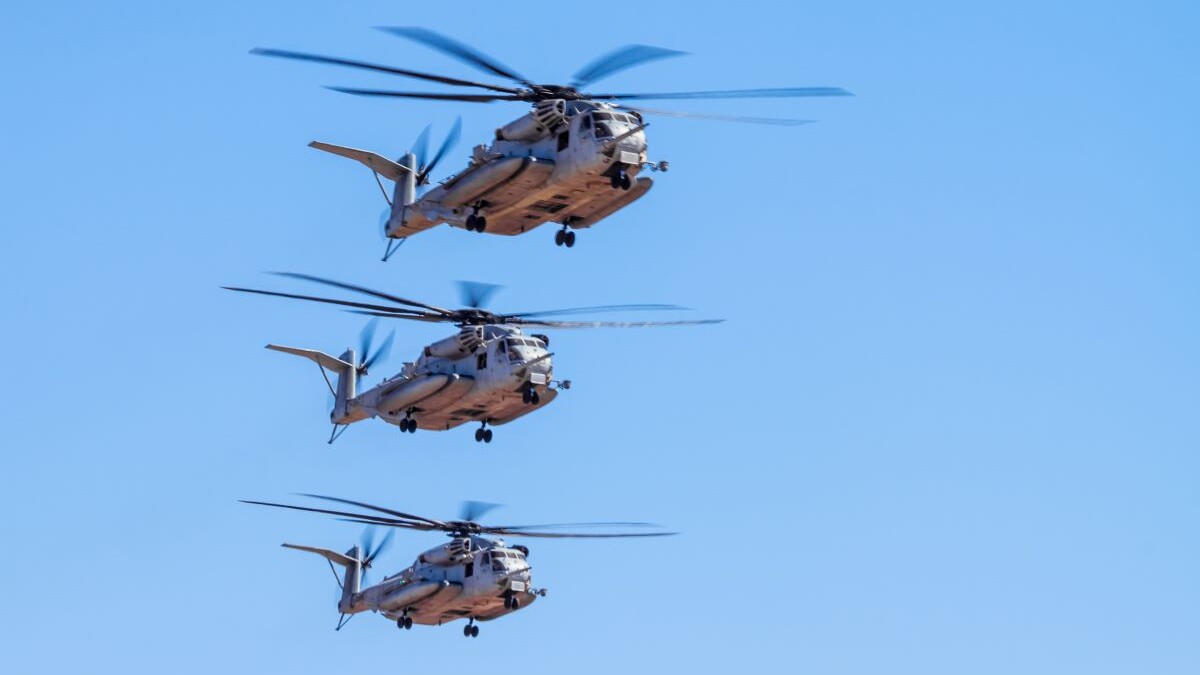 Sikorsky CH-53 Sea Stallion Military helicopter in formation and carrying cargo humvee