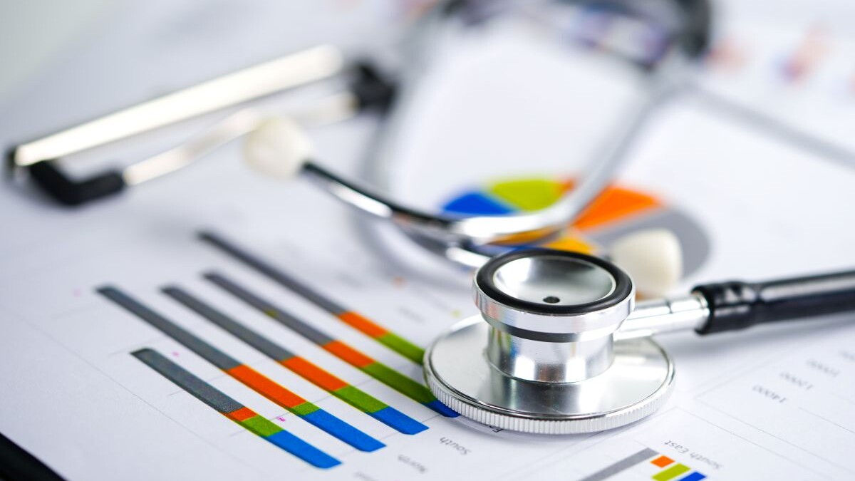 Stethoscope and US dollar banknotes on chart or graph paper, Financial, account, statistics and business data concept.
