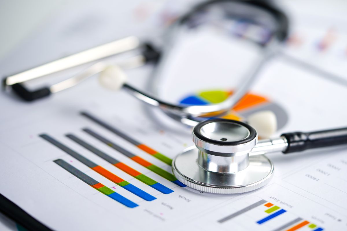 Stethoscope and US dollar banknotes on chart or graph paper, Financial, account, statistics and business data concept.