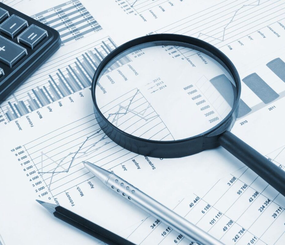Business concept with magnifying glass, calculator, pen, pencils and financial documents