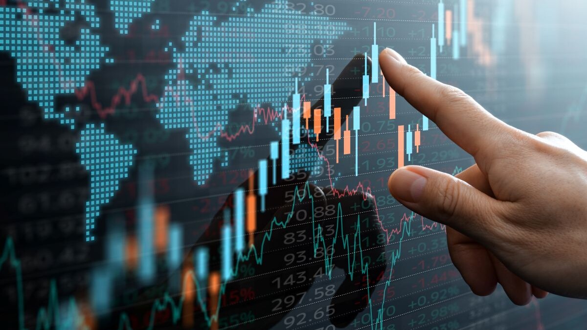 Graphs and world financial markets data. Investor pointing at the candlestick chart.