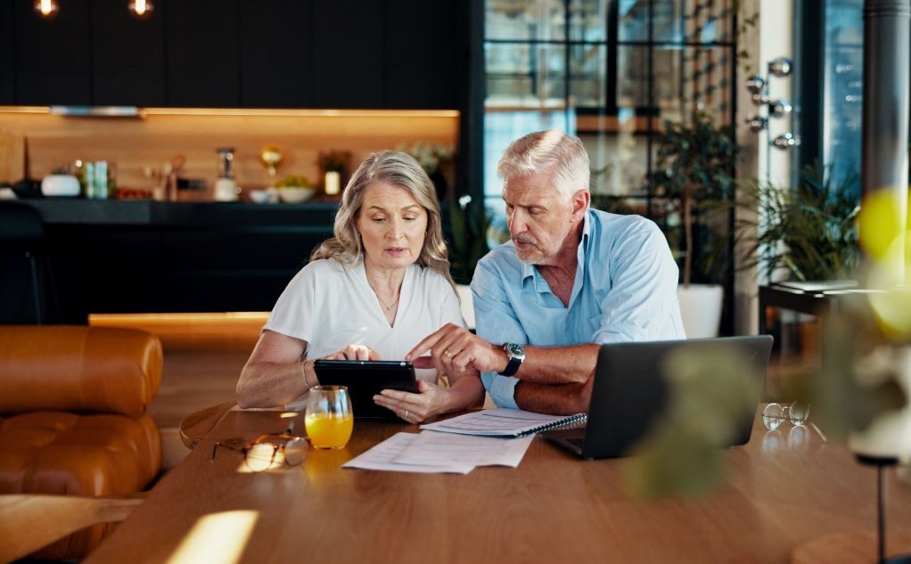 Tablet, planning and budget with old couple at home for social security benefits, annuity growth and retirement fund. Account balance, online banking and 401k withdrawal with people